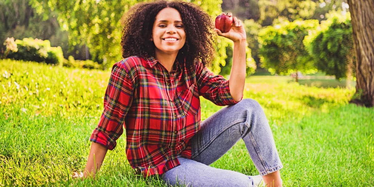 Smiling woman holds apple