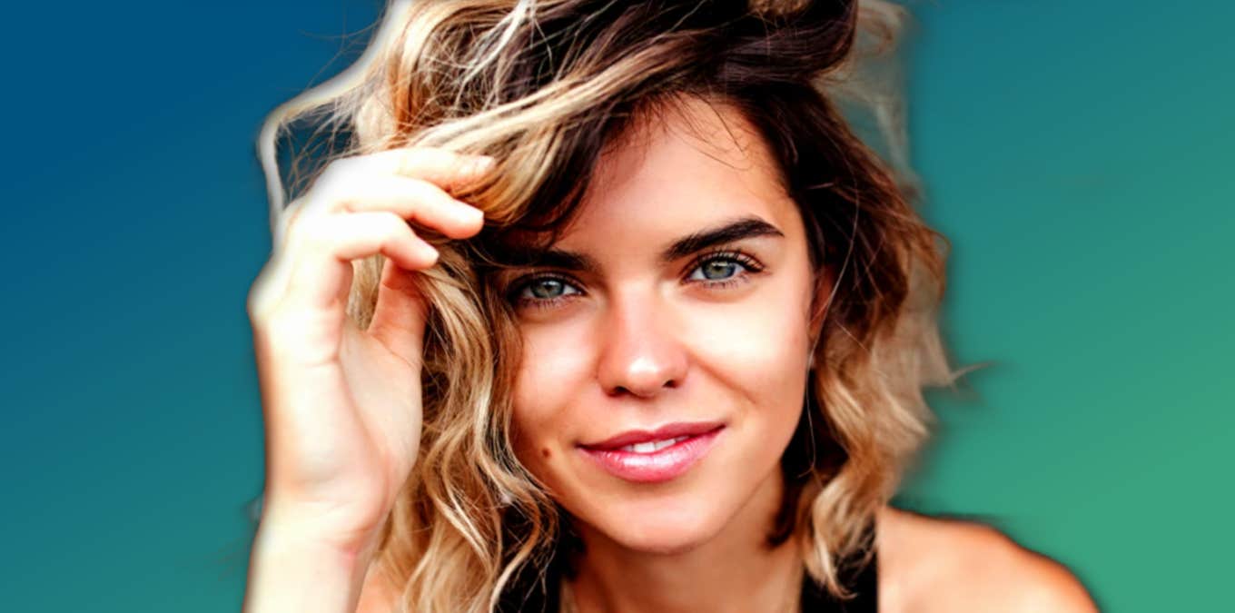 woman with green eyes and curly hair smiles at camera, green background 