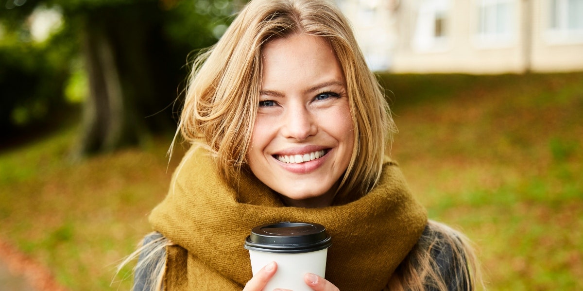 new year goals smiling woman holding a coffee cup