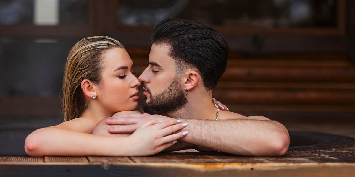man and woman kissing in hot tub