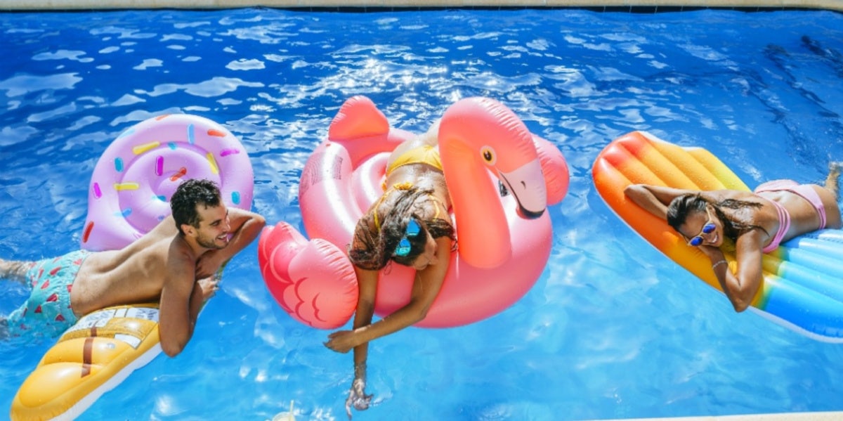 friends swimming in the pool with floaties