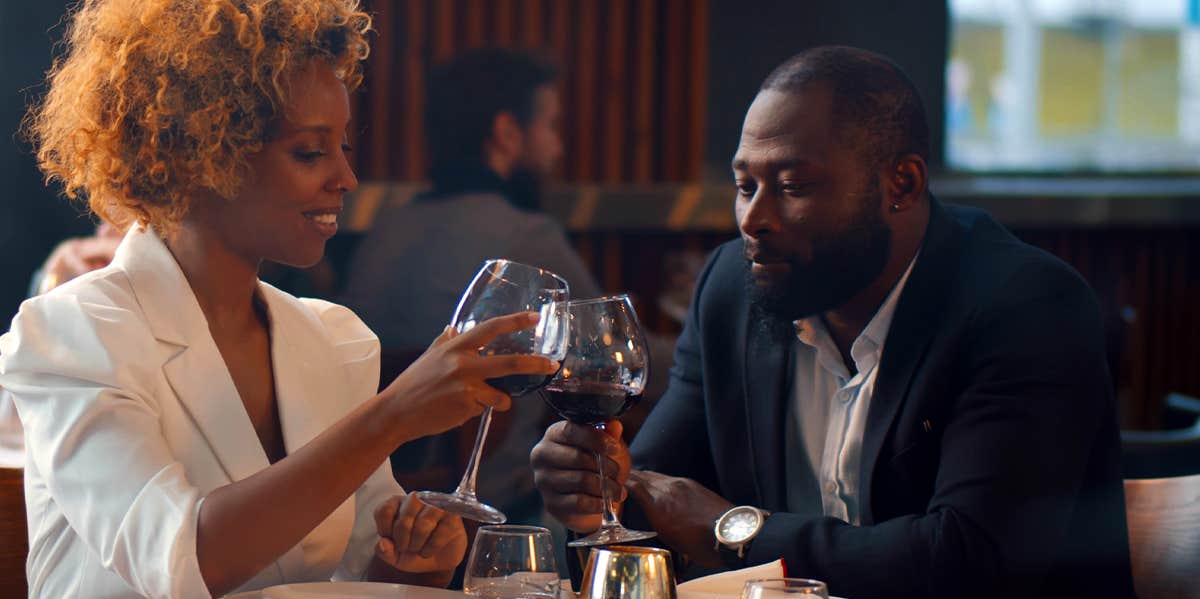 man and woman enjoying wine on date