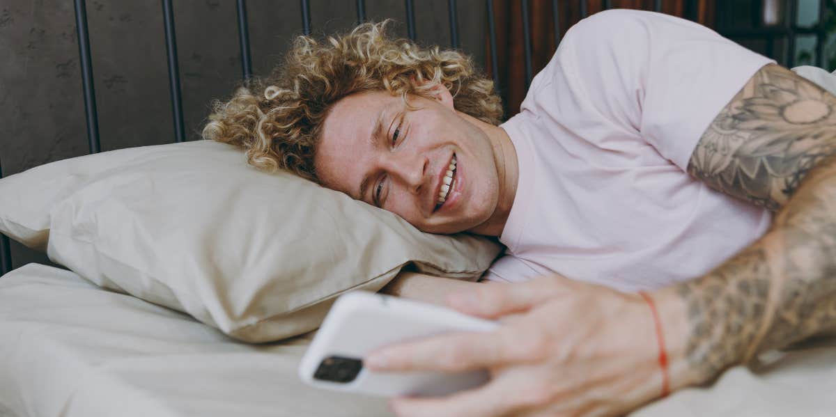 man texting in bed