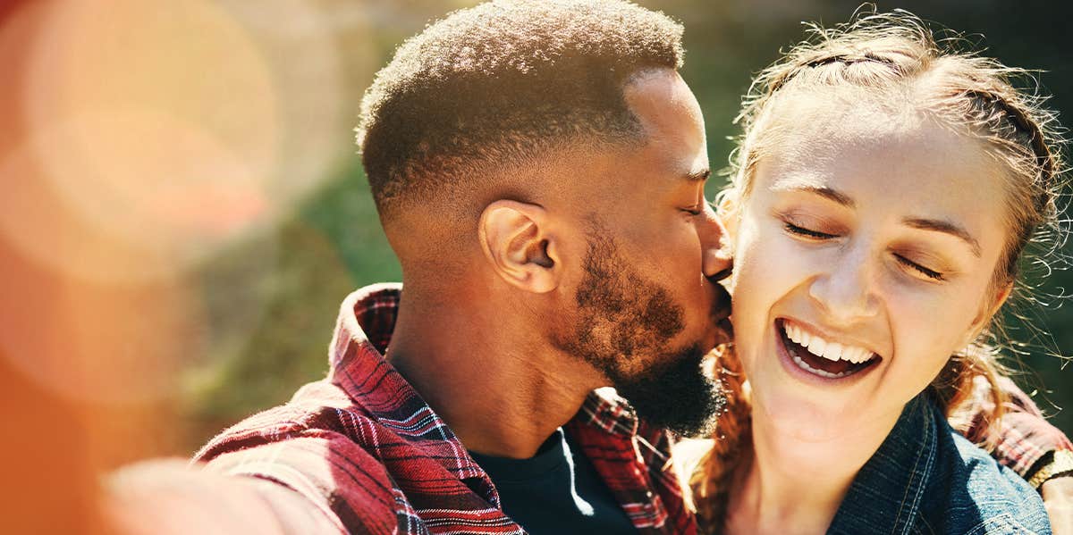 man kissing woman on cheek