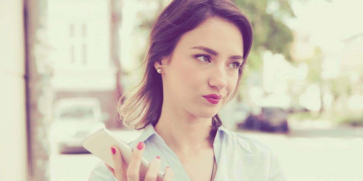 annoyed looking woman holding a smartphone