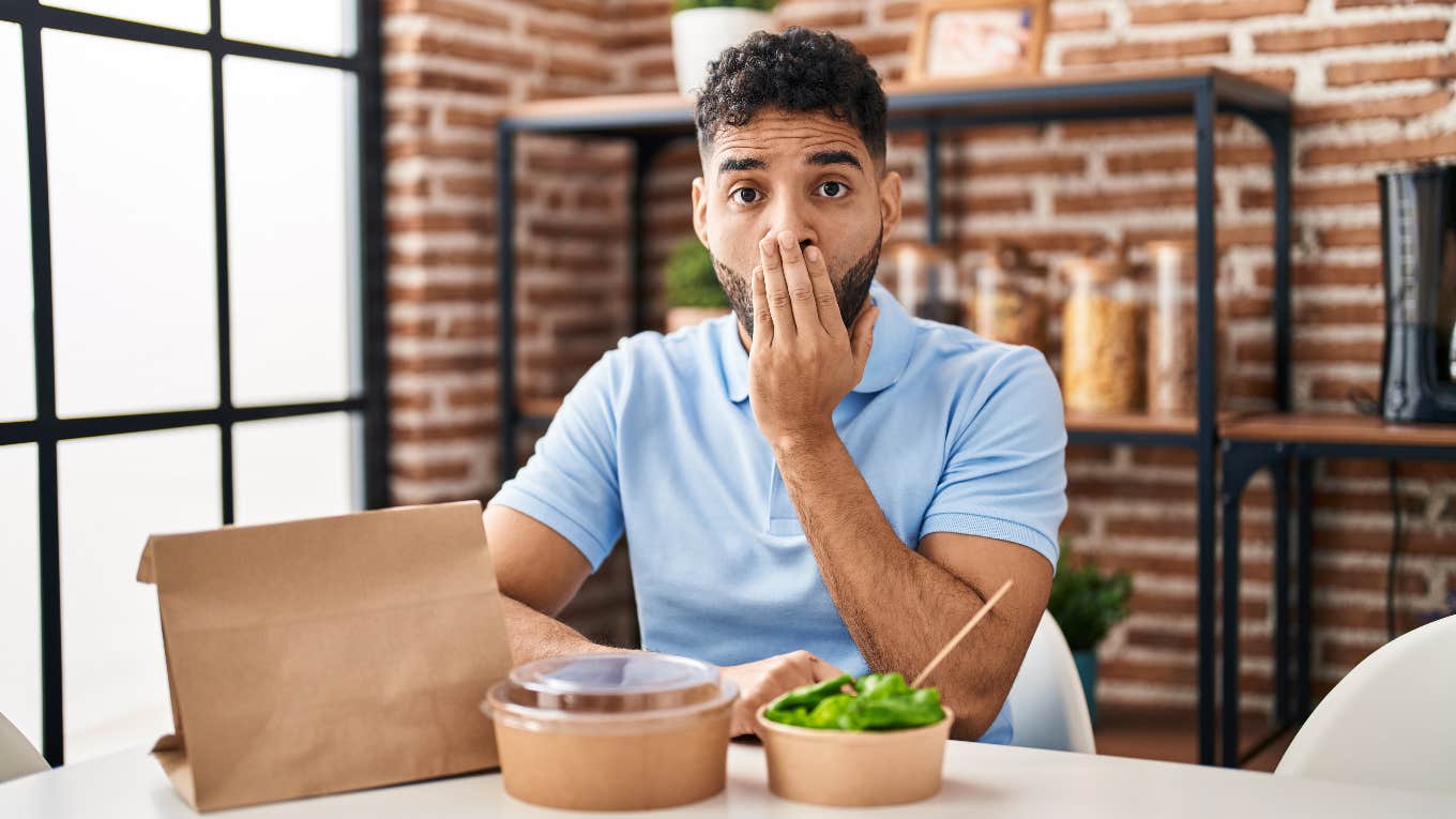 surprised man eating stolen food at work