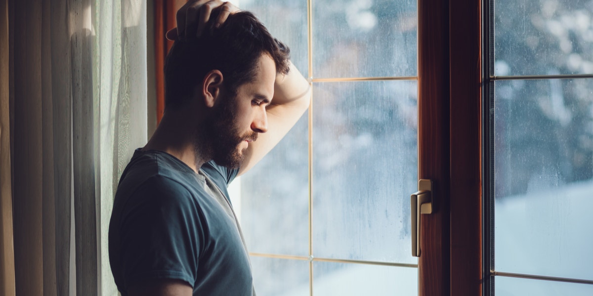 man looking out window