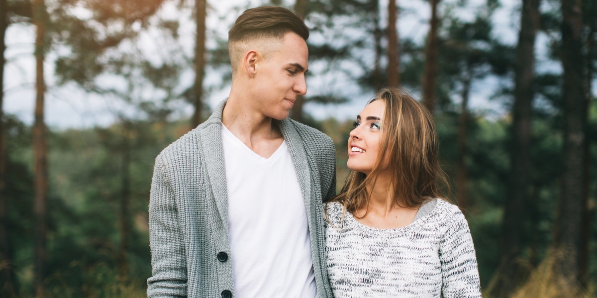 man and woman looking at each other in the woods