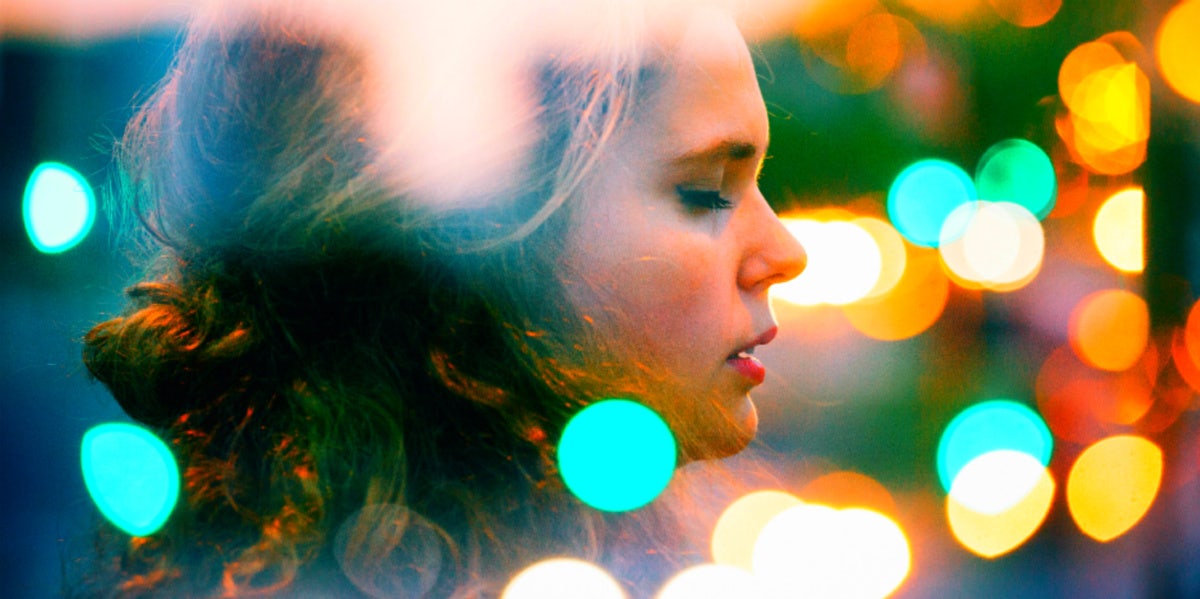 woman surrounded by colorful orbs eyes closed