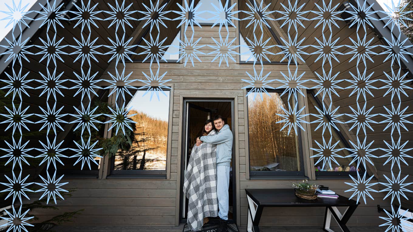 Couple cuddled close to each other at their cabin door