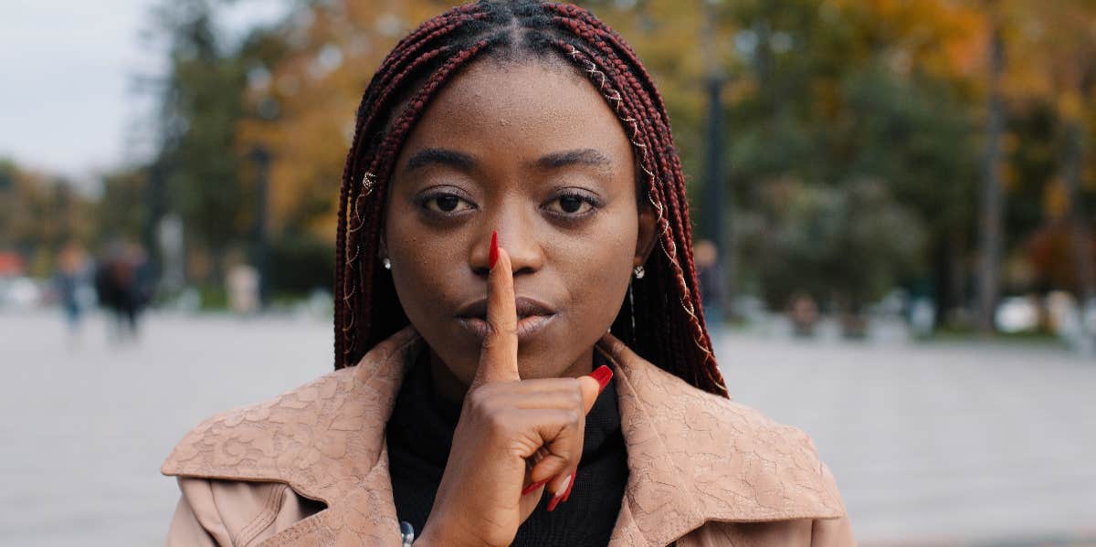 lady with finger over mouth