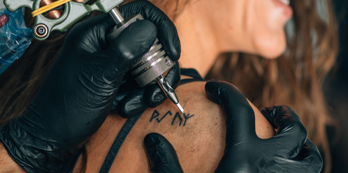 woman getting one word tattoo