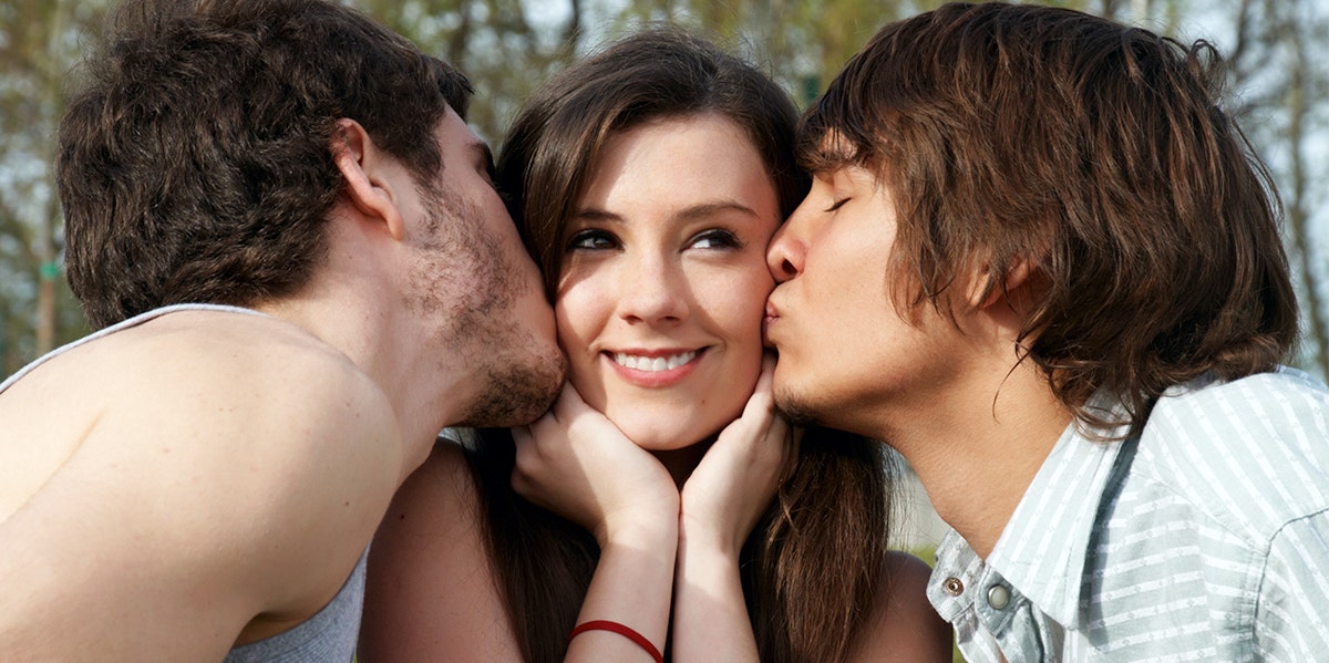 two men kissing woman on cheek