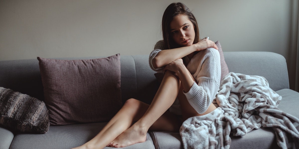 orgasm problems sad woman sitting on couch