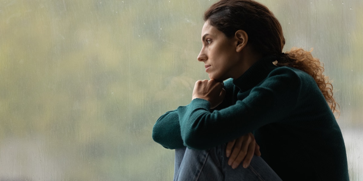 worried woman looking out window