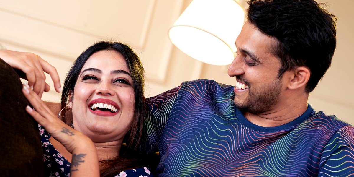 How To Talk To The Person You Love About Anything couple laughing together on couch