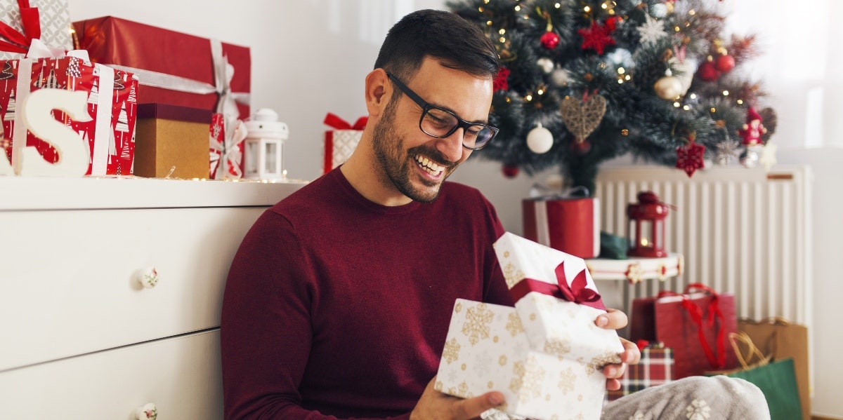 man opening Christmas presents man opening Christmas presents