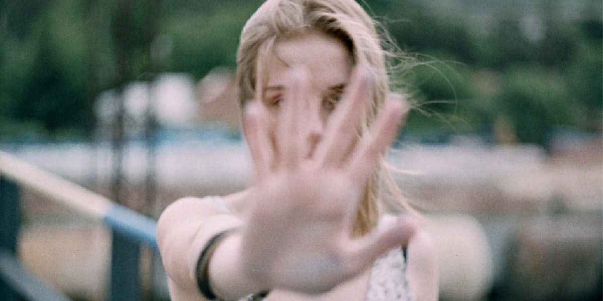 woman holding her hand palm in front of her face