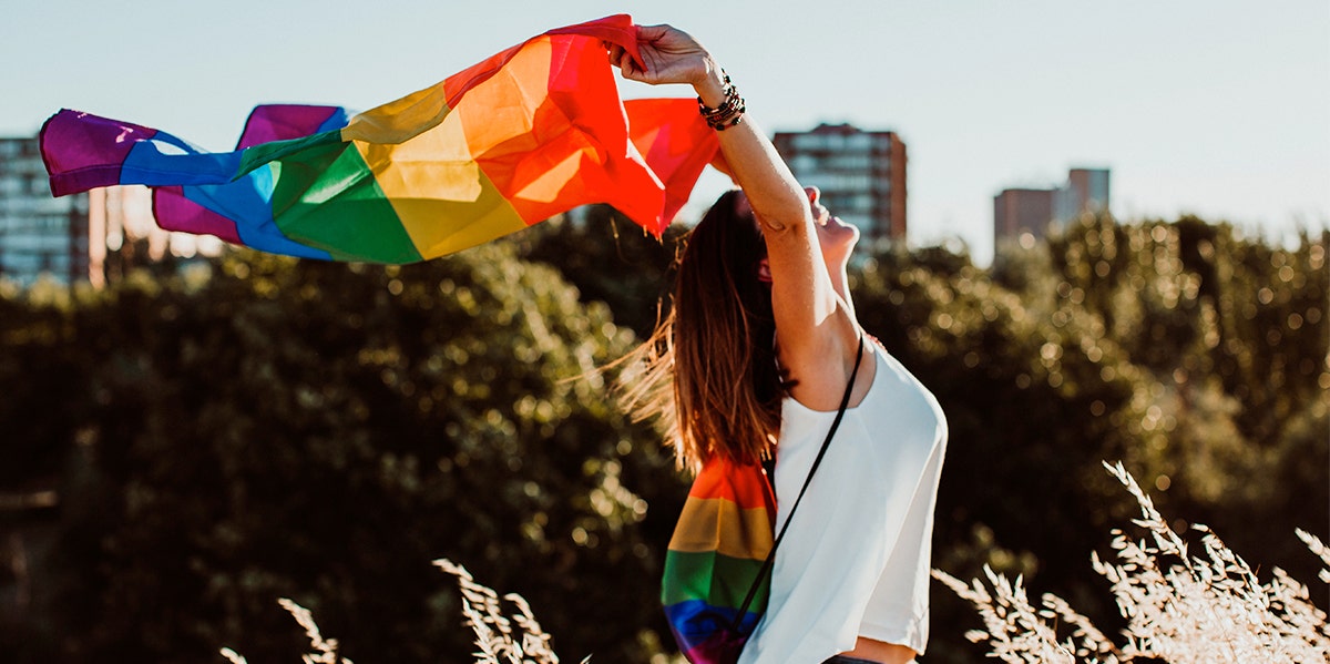 woman holding up a gay pride flag