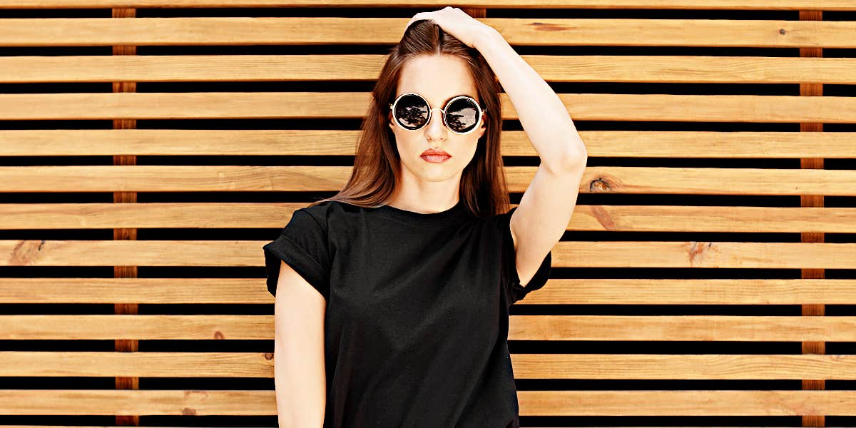telltale signs you're in parasitic relationship serious woman standing against slatted wall