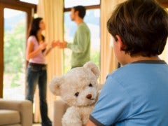 parents fighting in front of son holding teddy bear