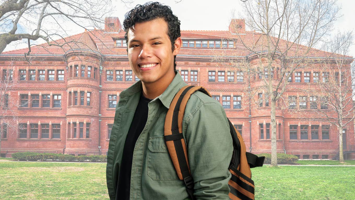 College student smiling in front of college campus. 