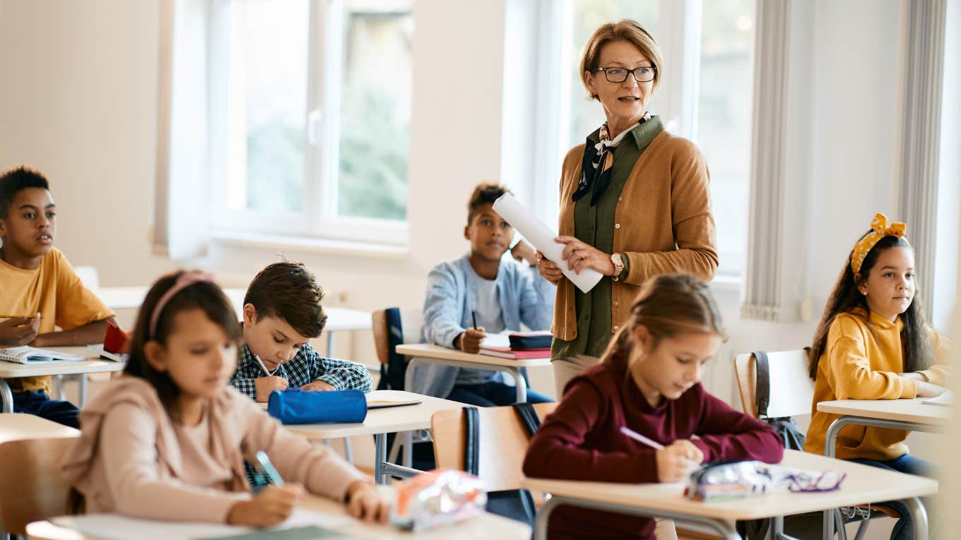 Parents Sue School After Elementary School Teacher Locks 10-Year-Old Student In A Closet For Laughing teacher holding a class to group of school kids at primary school.