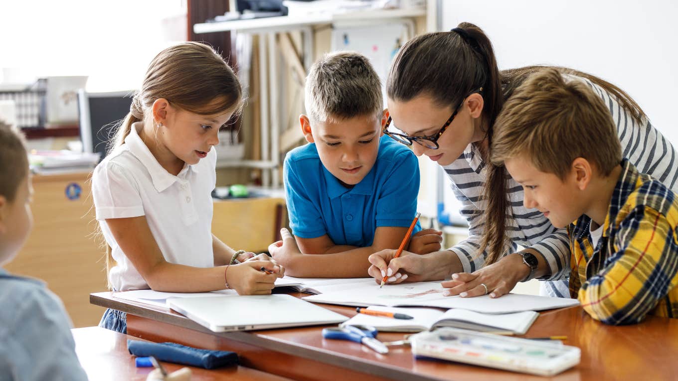 teacher helps school kids to finish they lesson