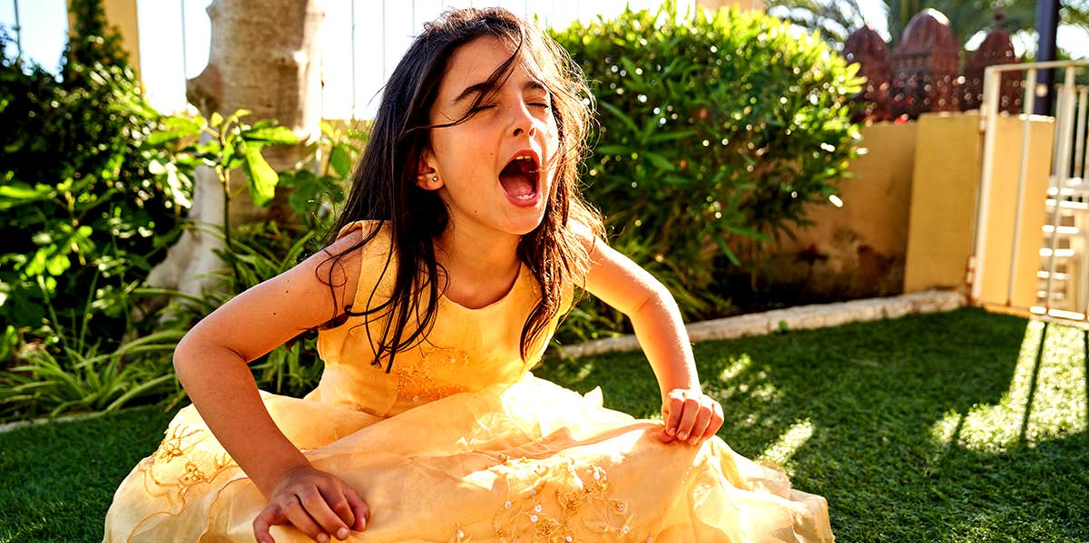 little girl in yellow dress throwing a tantrum