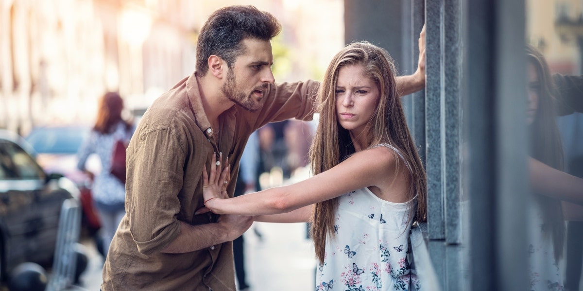 scared woman pushing angry man away