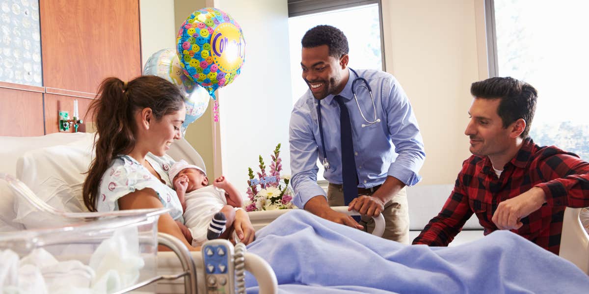 Family and a doctor in a hospital room with a newborn baby