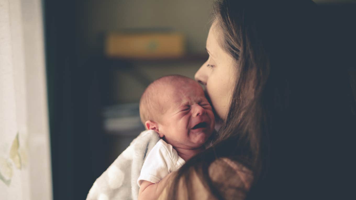 woman holding crying baby