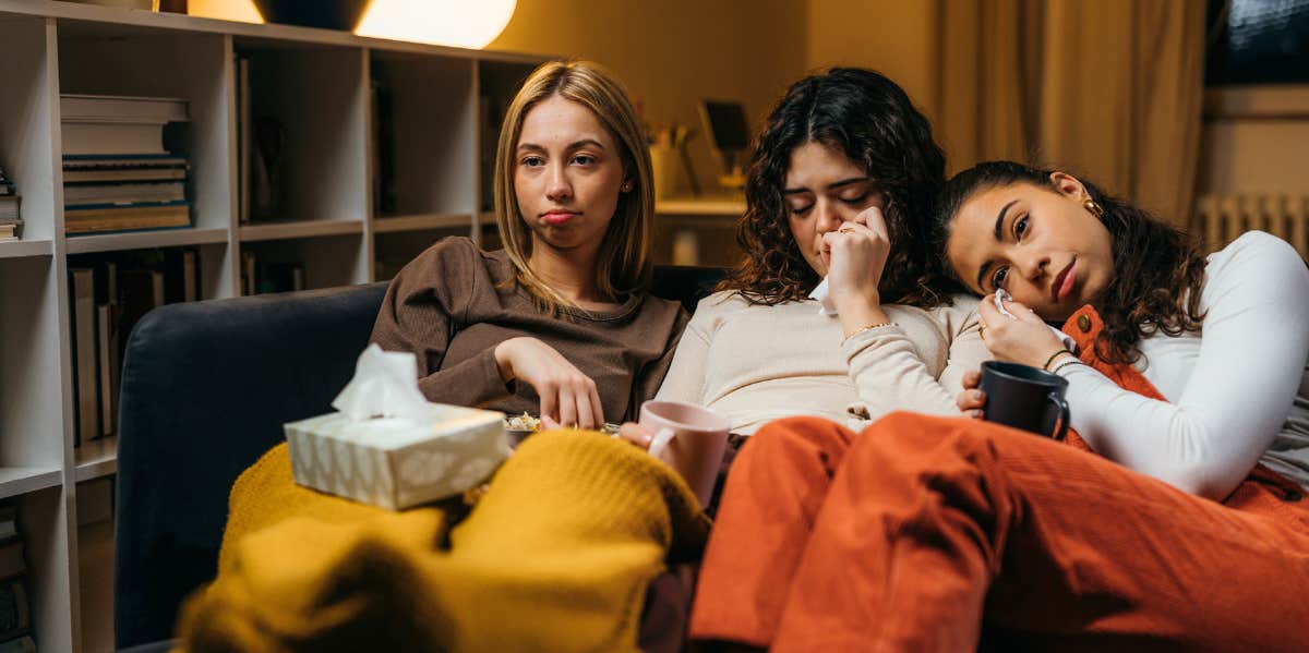 three friends crying on the couch