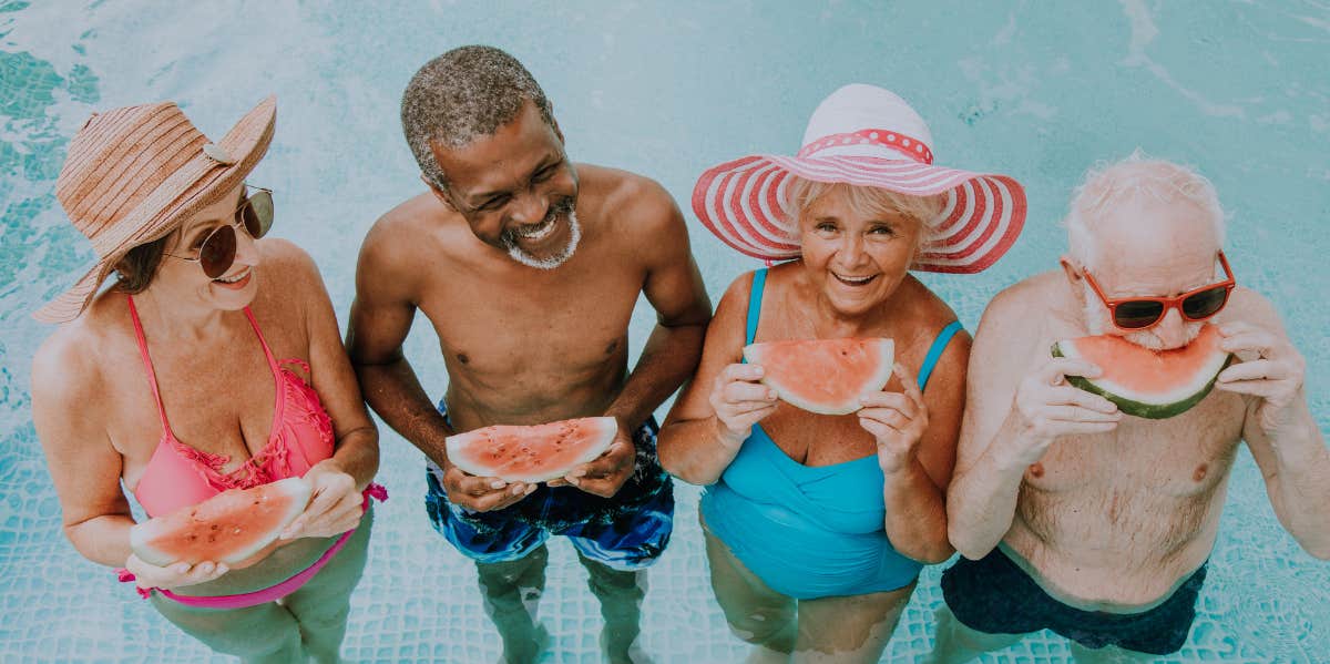 People With These Dominant Personality Traits Know How To Live Long, Happy Lives group of older men and women in a pool, looking happy and eating watermelon