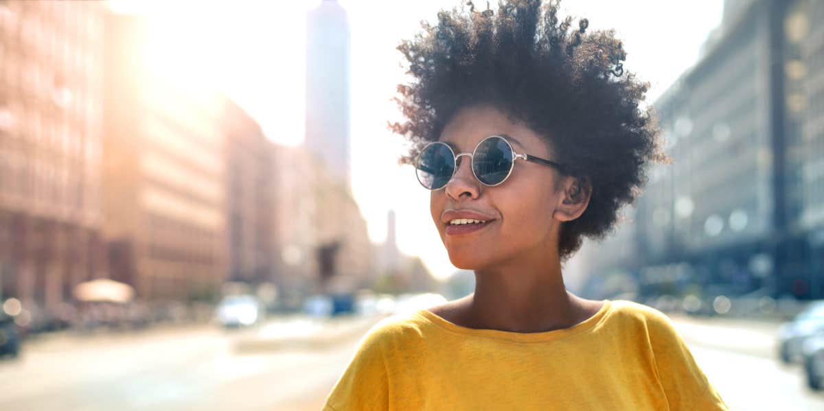 woman walking in sunlight with sunglasses on