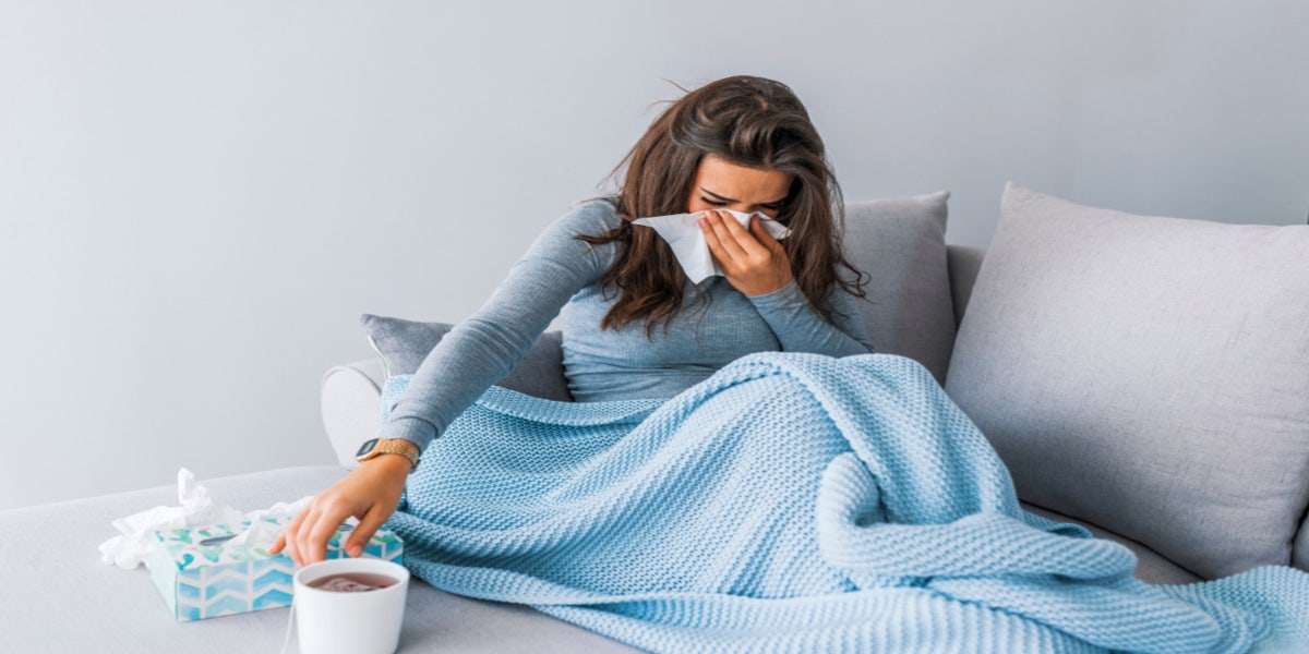 sick woman with tissues in bed