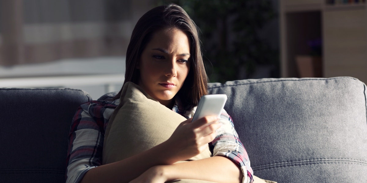 personal attacks on social media woman looking at her smartphone