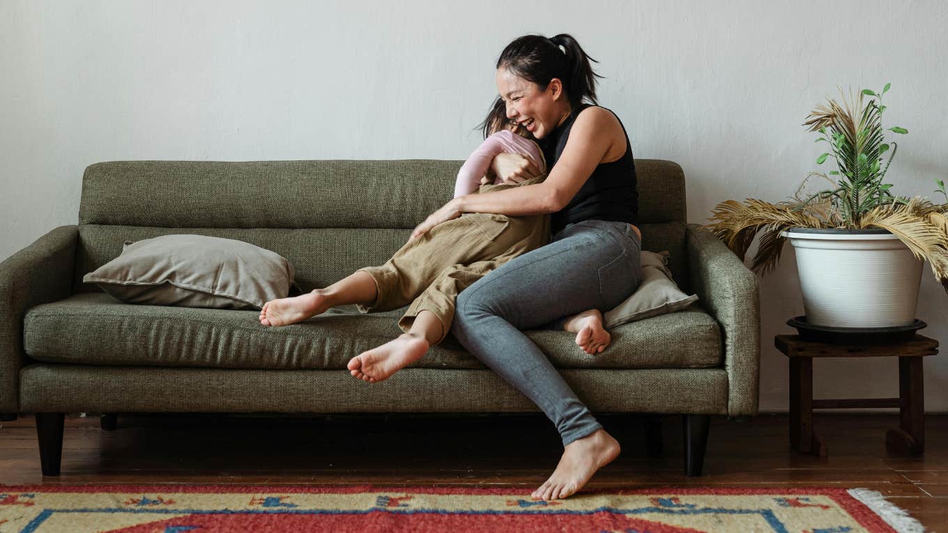 mom snuggling daughter on couch