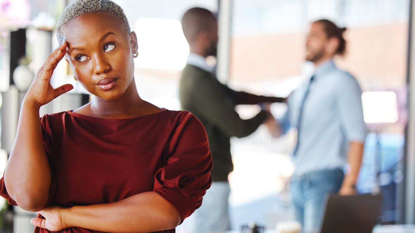 Woman showing no compassion for people arguing in the background 