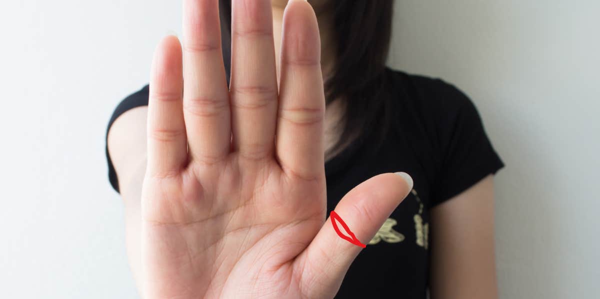 Phoenix Eye On Thumb: 6 Meanings woman holding her hand up