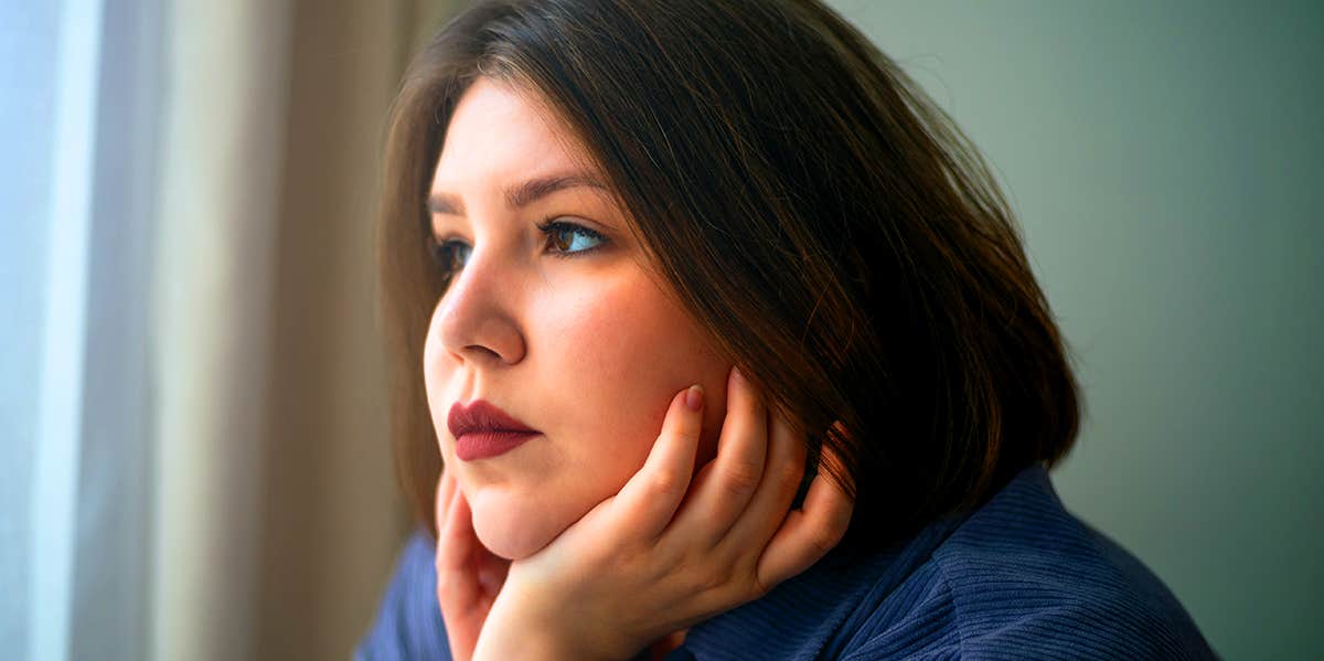 lonely woman looking out window