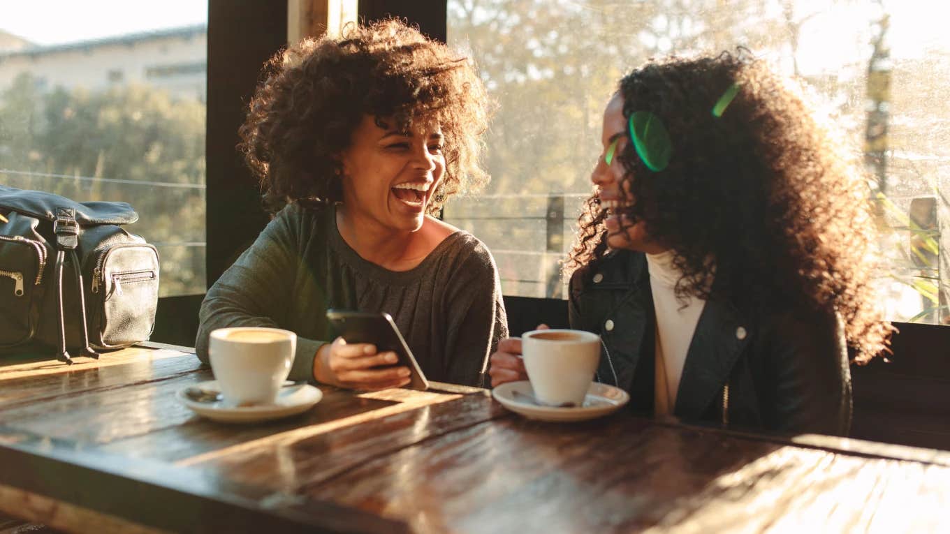 women talk and laugh at a cafe