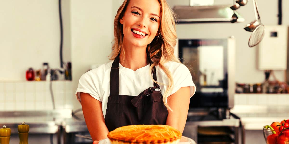 woman holding a pie smiling for Pi Day
