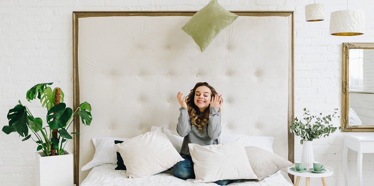 The Crazy Thing Your Throw Pillows Reveal About Your Relationship woman in bed with pillows
