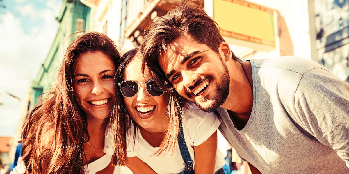 Three friends smile for the camera