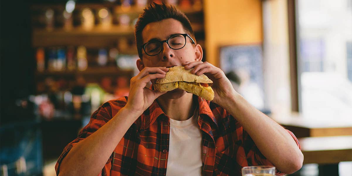 man eating sandwich at restaurant