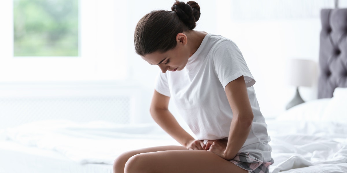 a woman holding her stomach cramping