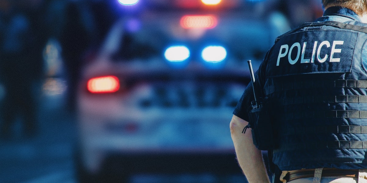 policeman with police car in the background