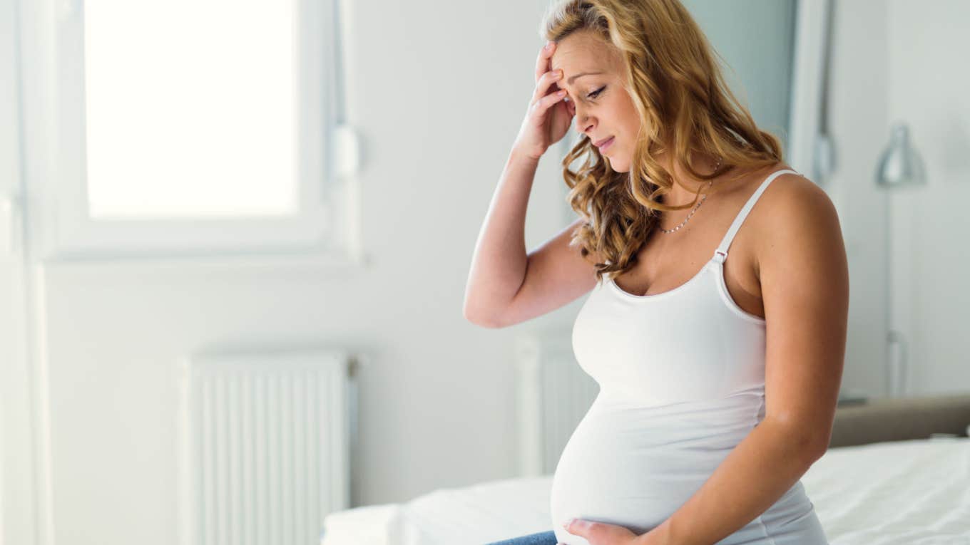 pregnant woman struggling with nausea and headache pain