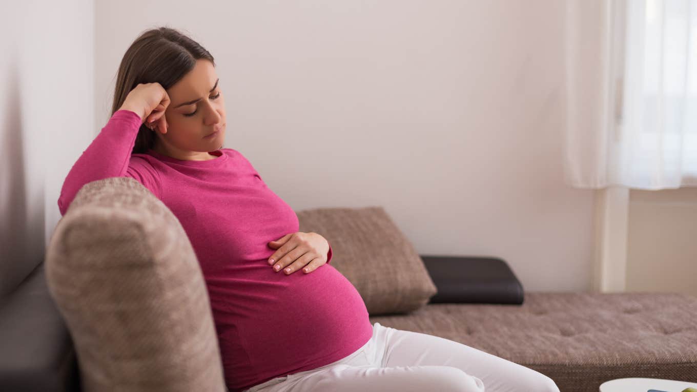 sad pregnant woman on couch